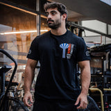 Man wearing a black t-shirt with a logo in an urban setting