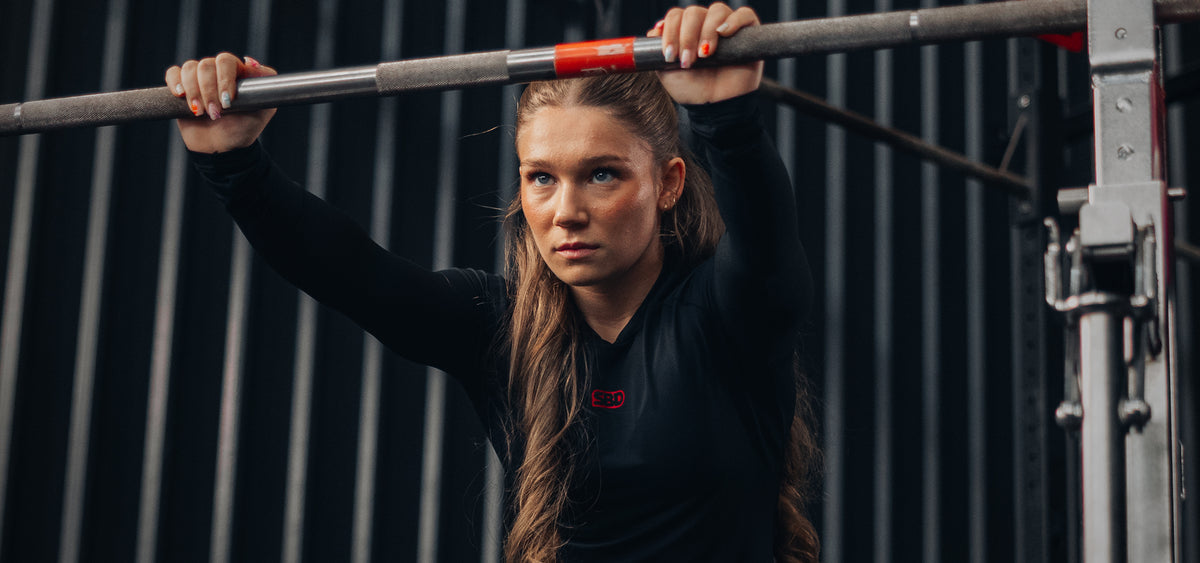 SBD Classic Refresh - athlete in black long sleeve setting up under the bar